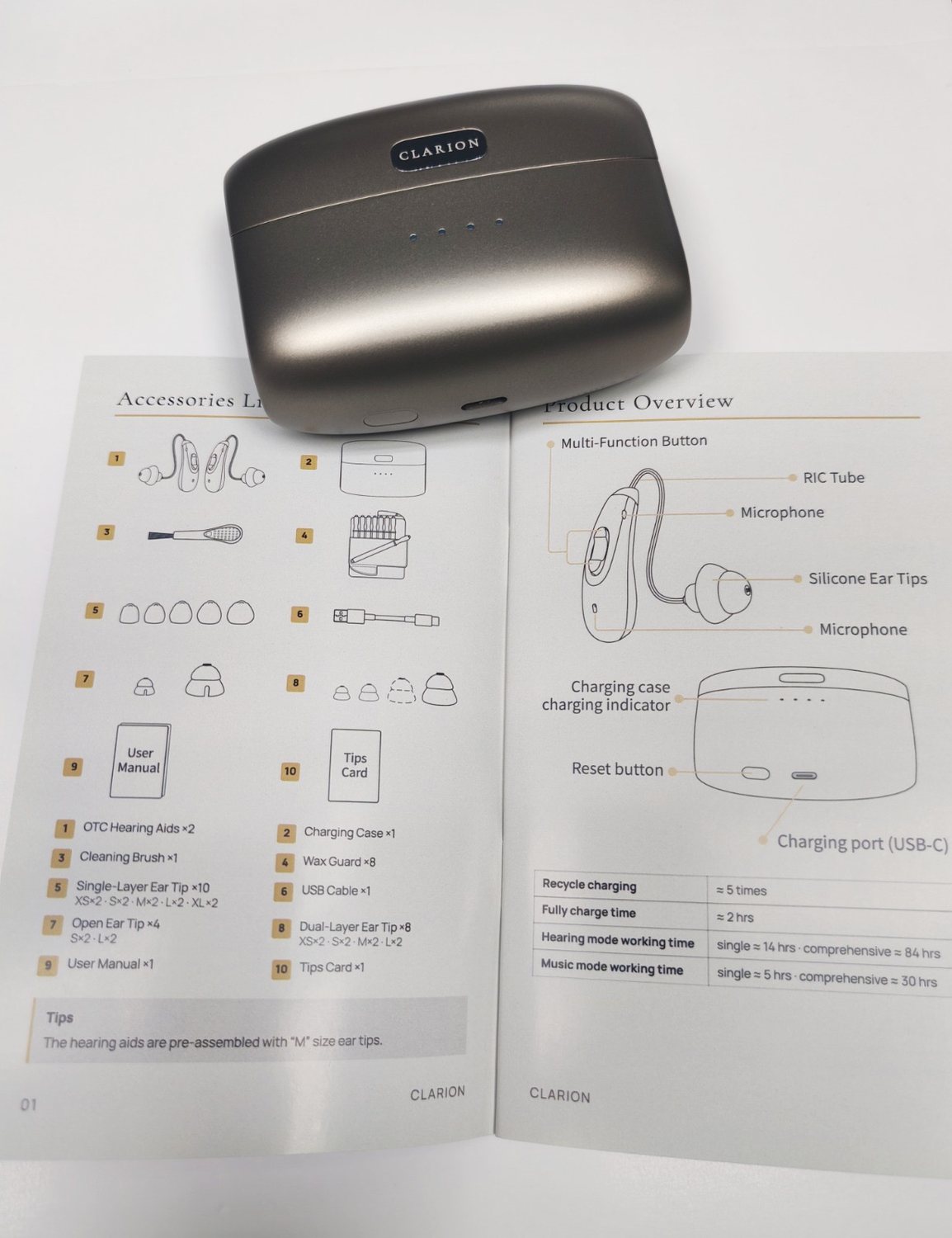 The printed Clarion manual open at the accessories and controls overview page, with the charging case resting on it.