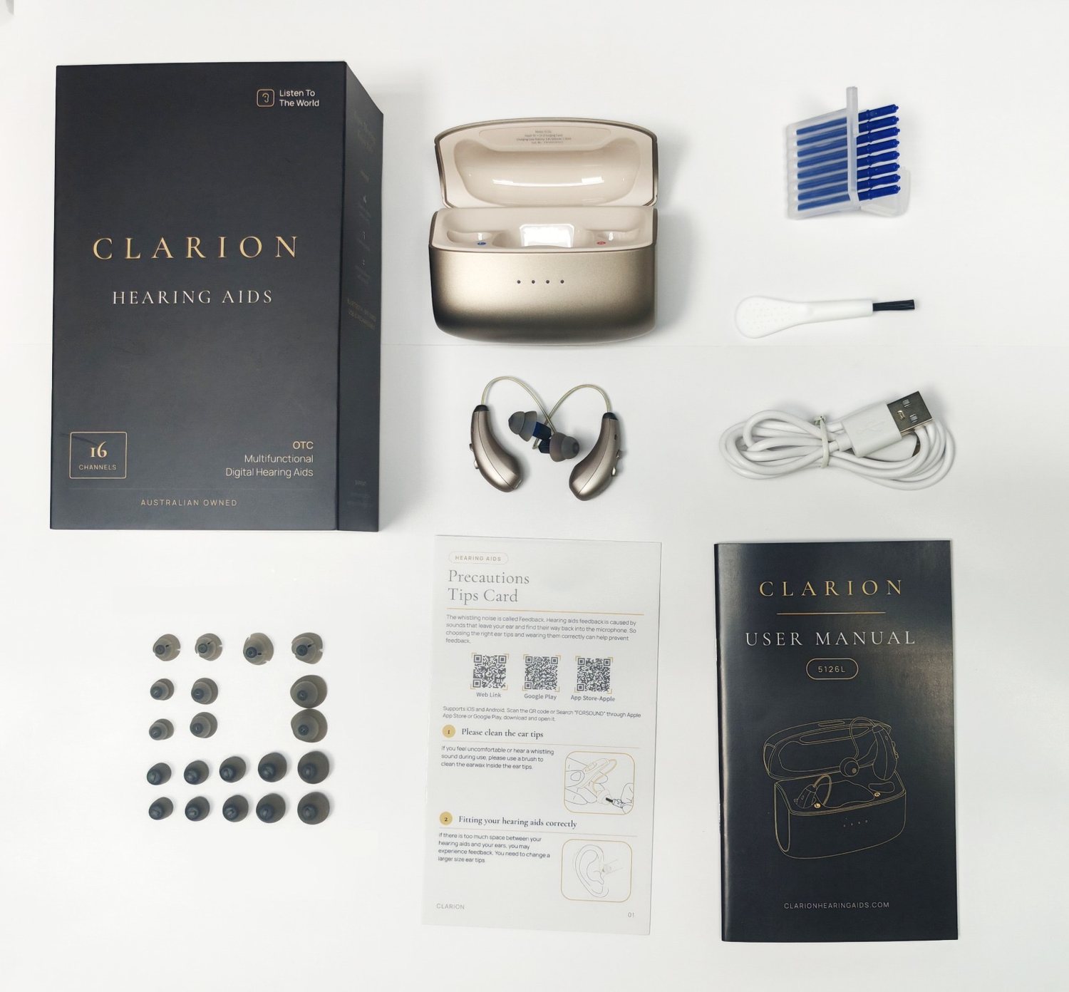 The full Clarion kit laid out: two hearing devices, charging case, USB-C cable, ear tips, wax guards, cleaning brush, tips card and manual.